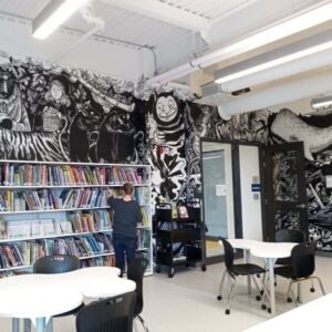 Photo d'une murale peinte au mur d'une bibliothèque.